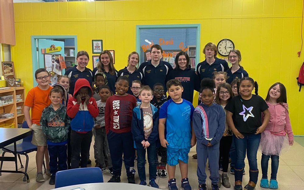 Image depicts students gathered together for photo op in school library.